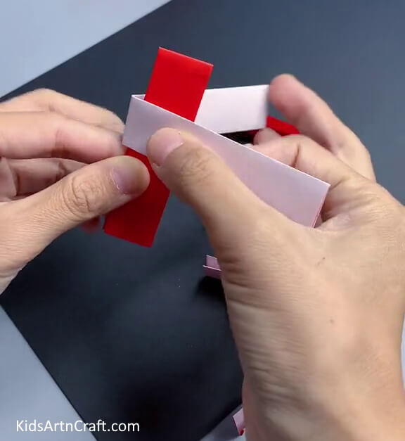 Attaching Half-folded White Paper Strip To Red Half-folded Strip - A Comprehensive Guide on How to Construct a Paper Toy Easily