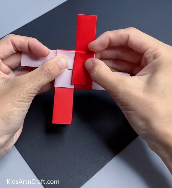 Folding Top Layers Of Paper Strip Inwards - A Step by Step Guide to Making a Simple Paper Toy
