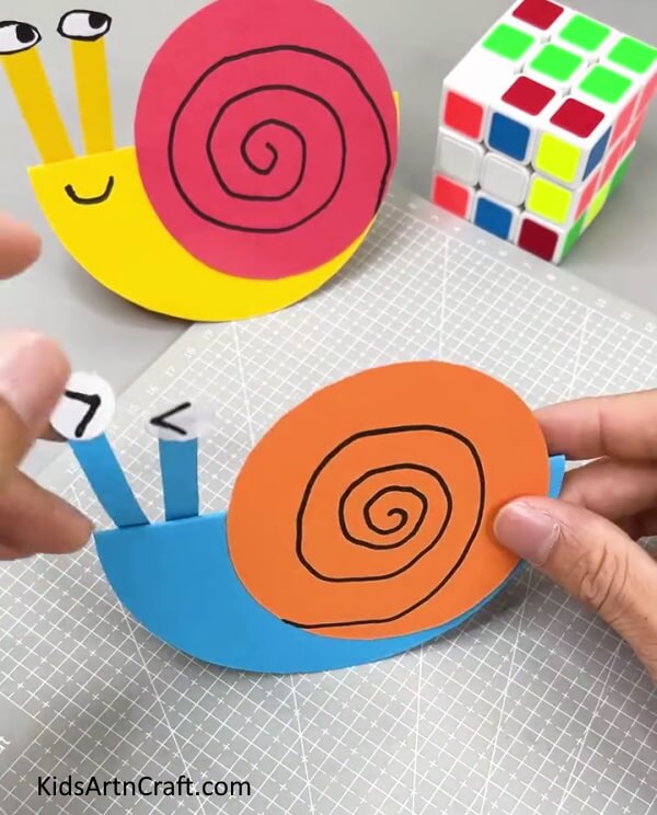 Pasting Eyes - A straightforward paper snail craft idea for children.