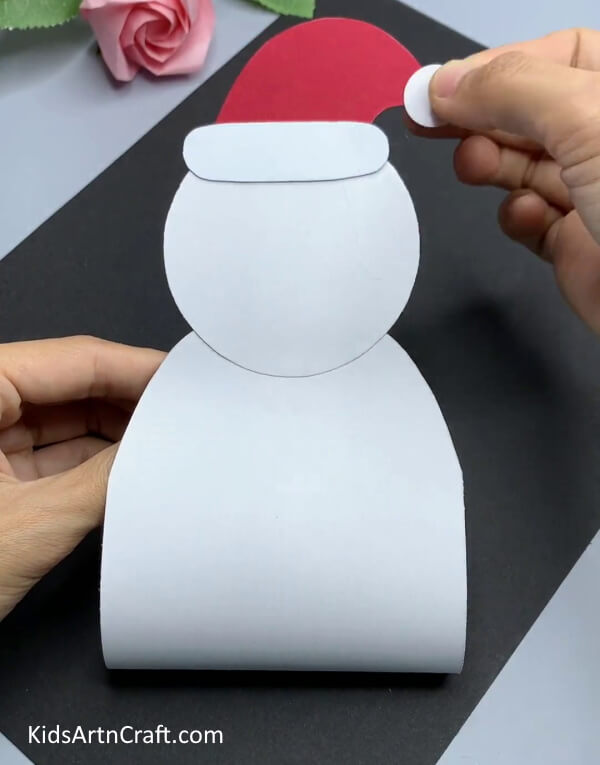 Pasting Small White Circle On Cap - An enjoyable snowman paper craft project for young Kindergarteners.