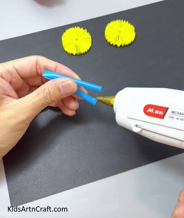Applying Glue Gun On Both The Ends Of The Straw - Making a Bicycle with Paper and Straws