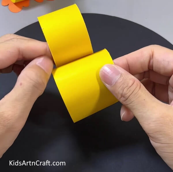 Pasting Two Yellow Rings - Crafting a paper duck toy - a fun activity for kids. 
