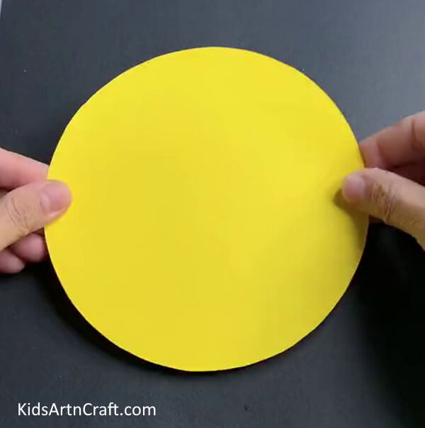 Cutting A Big Yellow Paper Circle - An easy paper tiger craft concept for children. 
