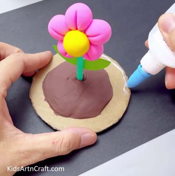 Applying Glue On The Boundary Of The Circle - Making Clay Flowers is a Breeze with this Comprehensive Tutorial 