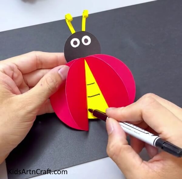 Drawing Details Using Black Marker - Make An Easy Ladybug Craft For Little Ones