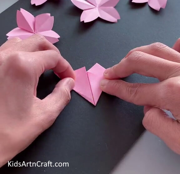 Folding Bottom Left Corner To Make A Triangle - A comprehensive guide to making an Origami flower with step-by-step instructions.