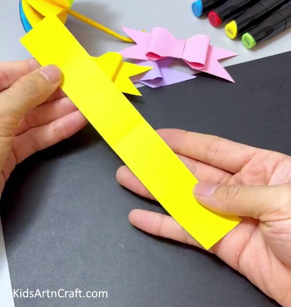Cutting A Yellow Paper Strip - Create a Simple Paper Bow Project for Kids