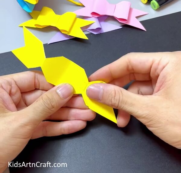 Pushing In The Paper To The Middle - Craft a Simple Paper Bow Activity for Little Ones