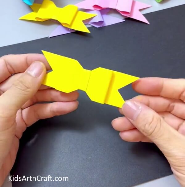Wrapping Yellow Strip in the Middle Of the Bow - Have children make their own paper bow project.