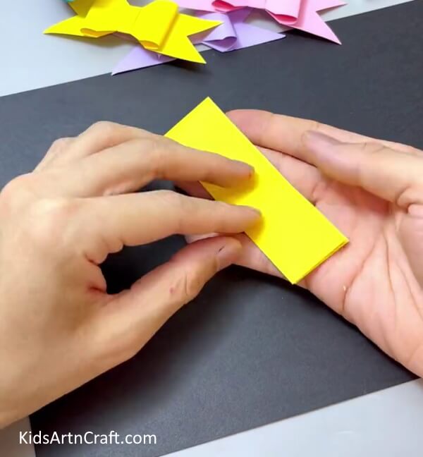 Folding The Strip In Half - Have Children Make Their Own Paper Bow Artwork