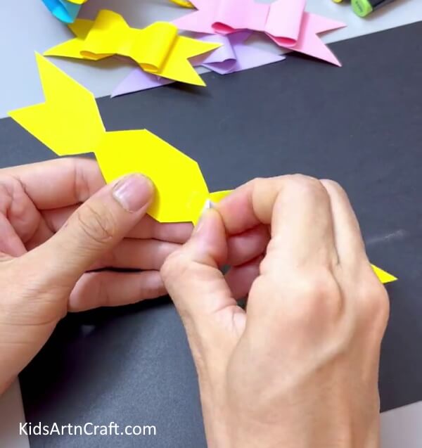 Unfolding the Paper and Applying the Tape - Have Kids Assemble Their Own Paper Bow Project