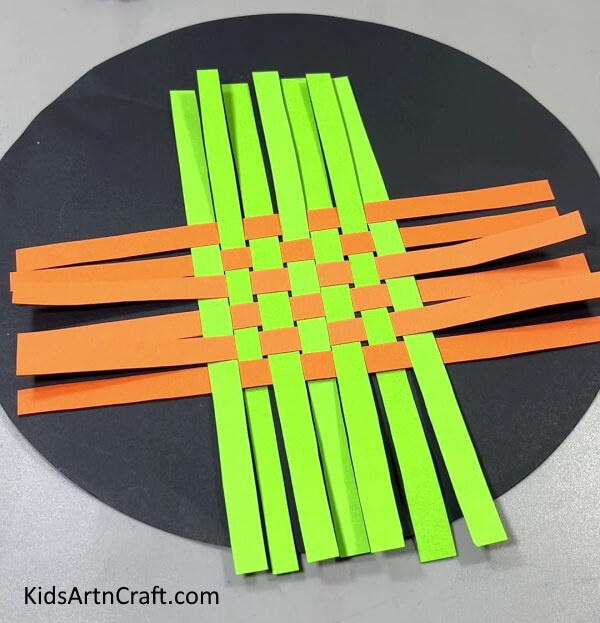 Weaving All The Orange Strips - A Tutorial to Teach Kids How to Make a Paper Strip Boat