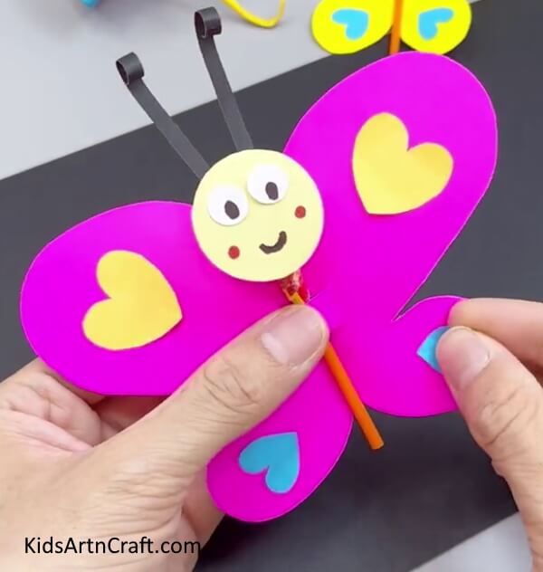 Pasting Colorful Hearts On Another Wing - Instructions for an uncomplicated Paper Butterfly Craft for Children 