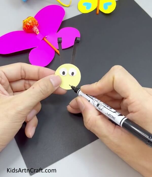 Adding Smile On Butterfly's Face - Crafting a Paper Butterfly - Straightforward Instructions for Kids