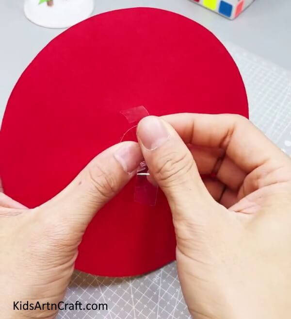 Applying Tape Over The Seal - Making a Paper Clock with Children - A Step-by-Step Guide