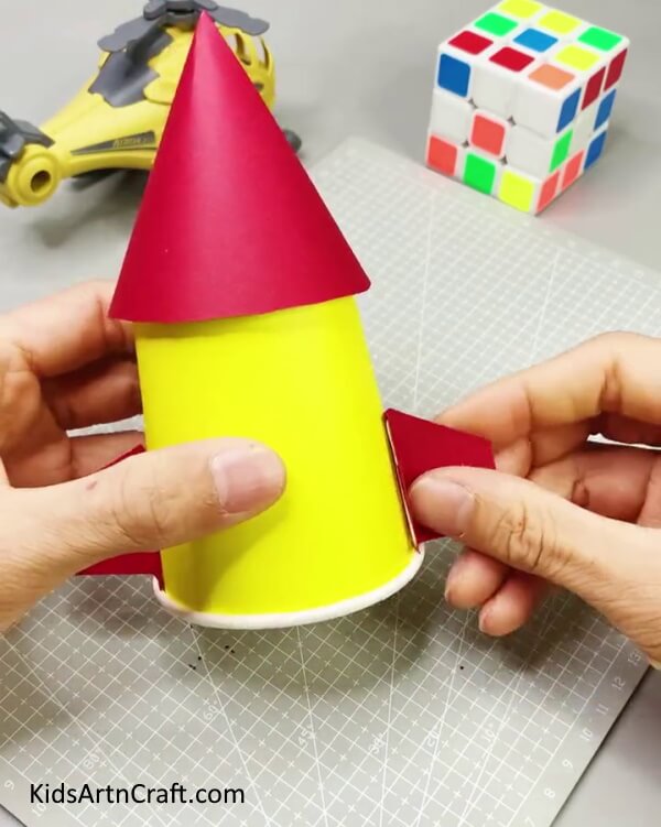 Adding Rocket Wings To The Wooden Stick -An innovative way for kids to reuse paper cups to build a rocket.