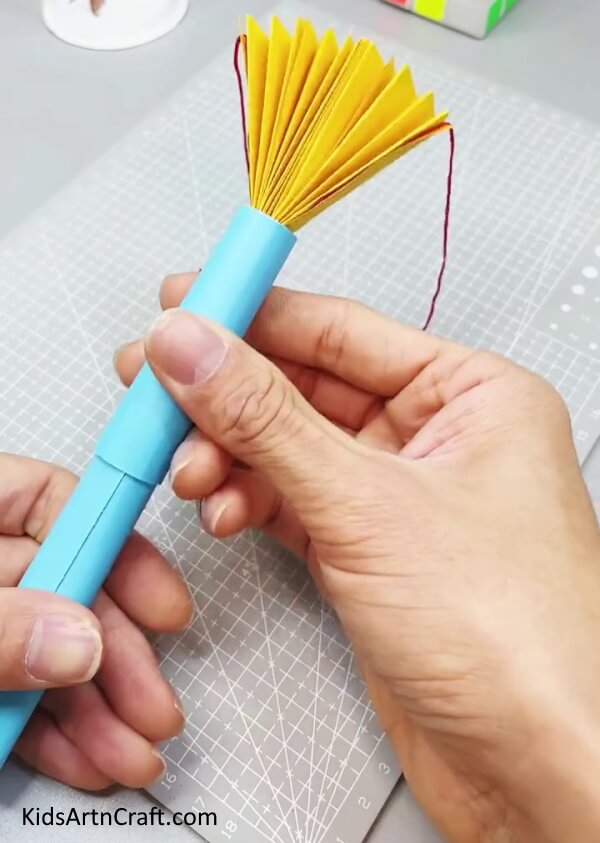 Bringing Top Blue Paper Roll Upwards - Crafting a paper fan plaything for kids to enjoy.