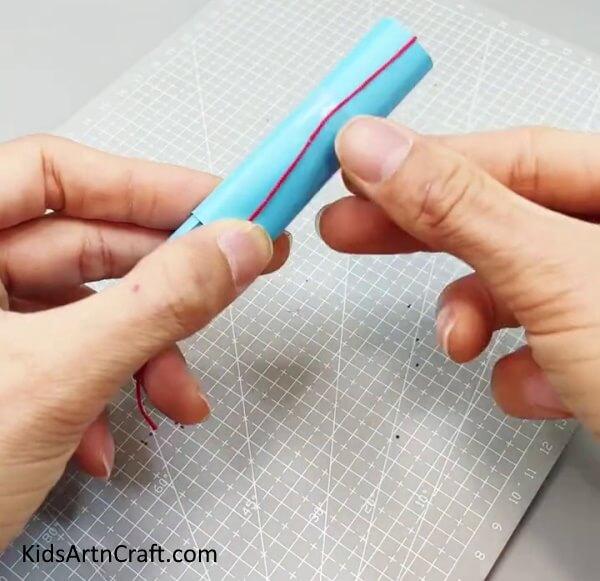 Pasting Thread On Blue Paper Roll - Creating a paper fan toy craft for children to have fun with.