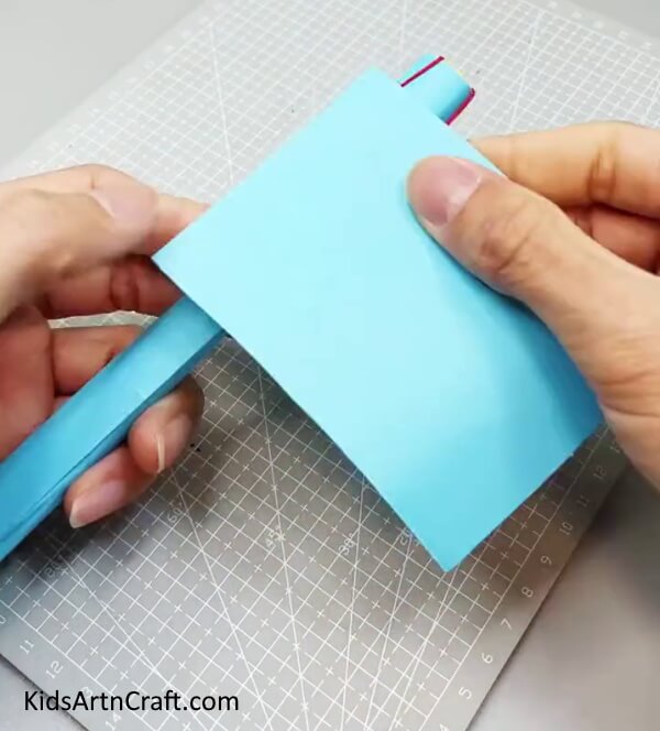 Wrapping A Blue Paper On the Top - Designing a paper fan toy craft for children to play with.