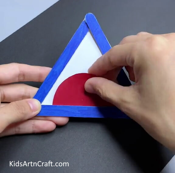Pasting A Red Semi-Circle - A basic craft for children to make a popsicle stick shark.