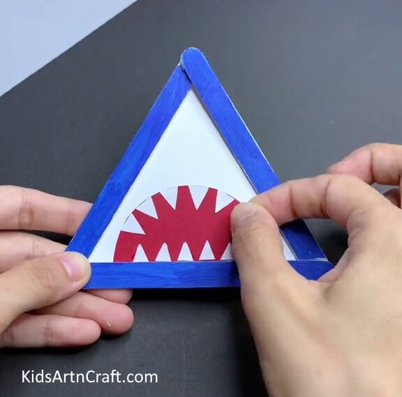 Pasting Small White Triangles To Make Teeth - An effortless popsicle stick animal craft for kids to make a shark.