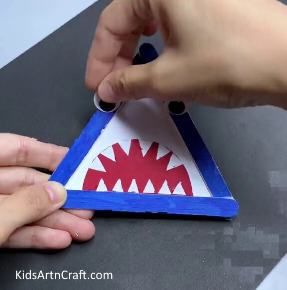 Making Eyes Of The Shark - A quick and easy animal craft for kids with popsicle sticks to construct a shark.