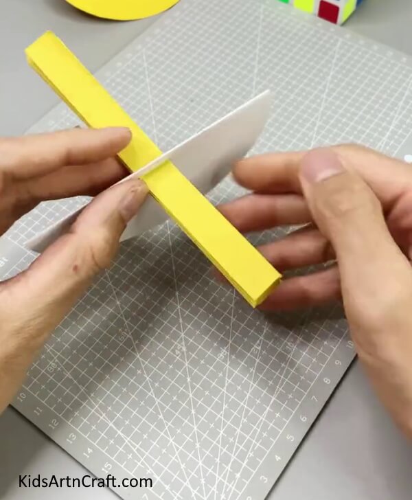 Inserting Yellow Paper Strip In Cut - Putting Together a Rocking Paper Bird For Kids