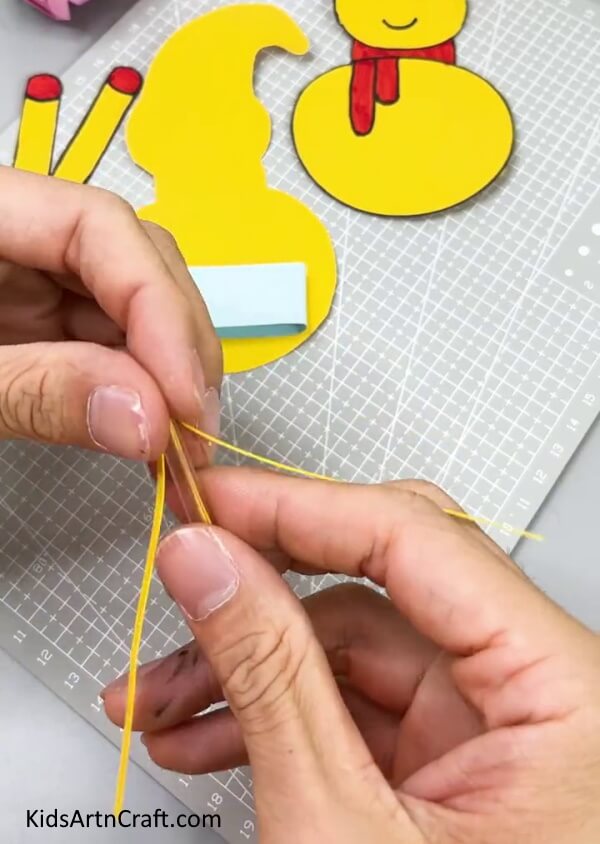 Cutting The Remaining Portion Of the Yellow Strip -A do-it-yourself tutorial to help kids craft a paper snowman
