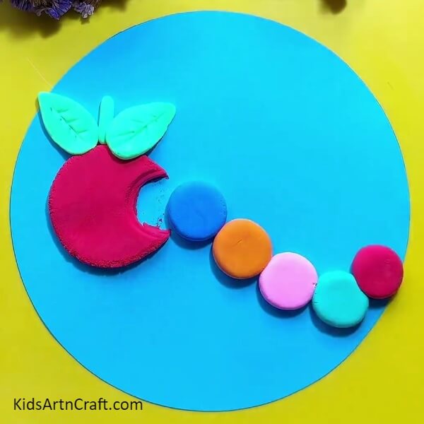 Similarly, place the dough of all the other colours- Creating a Clay Depiction of a Caterpillar Eating an Apple 