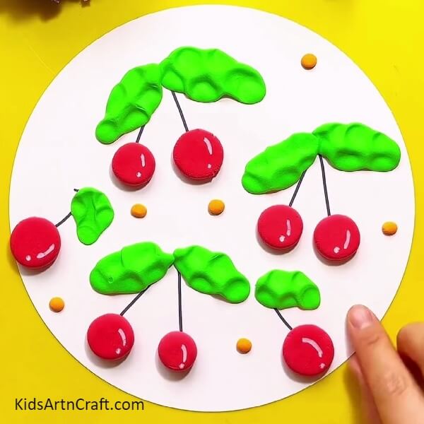 Make more background detailing with orange modelling clay - How-to Guide for Creating Stunning Clay Cherries for Children 