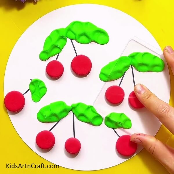 Start dabbing with transparent sheet red modelling clay balls to make cherries- Step-by-step Guide to Constructing Pretty Clay Cherries for Youngsters 