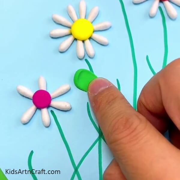 Using Clay To Make The Leaves Of The Flowers-Creating a flower garden out of cotton buds using a step-by-step guide for kids.