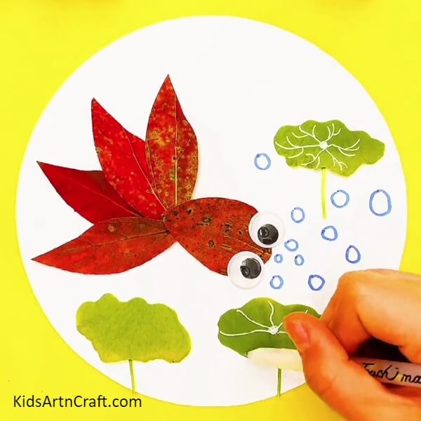 Make A Design On The Green Leaves To Make It Look More Realistic-Red Fish Swimming In Water for School Magazine