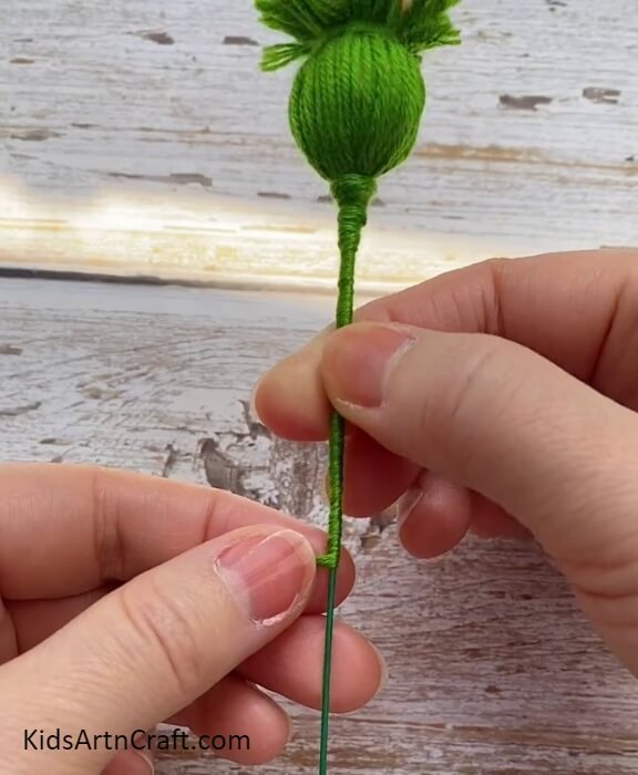 Rolling Excessive Green Thread Around A Floral Steel Wire- Directions to Constructing Splendid Wool Flowers with Children