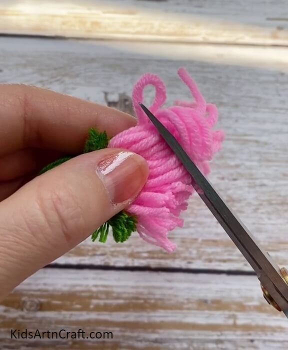 Cutting Extras From Pink Woolen Thread With Scissors- An Attractive Wool Blossoms Tutorial For Kids Step-by-Step 