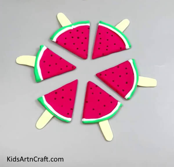 Inserting Ice Cream Sticks In All Slices - An instructional guide for creating clay watermelon ice cream.