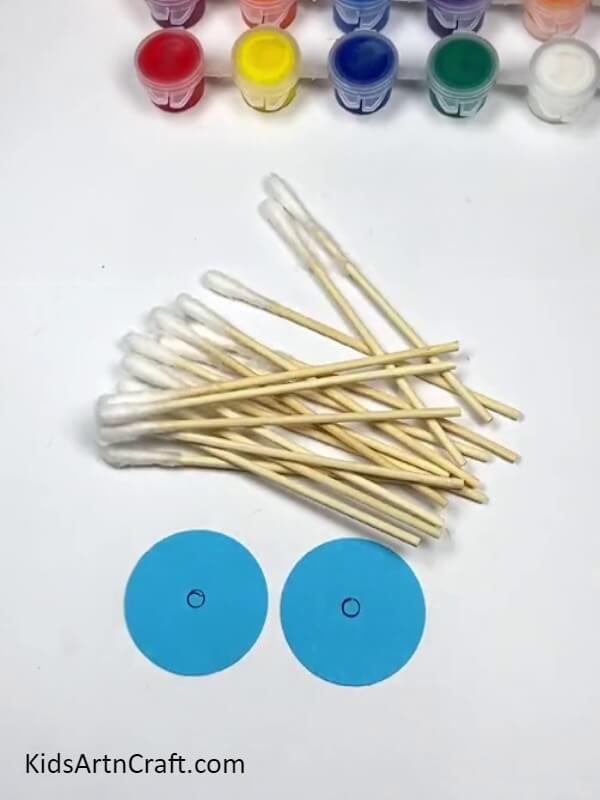 Taking Two Blue Circles And Cotton Earbuds - Step-by-Step Guide to Constructing a Colorful Cotton Earbud Windmill for Novices 