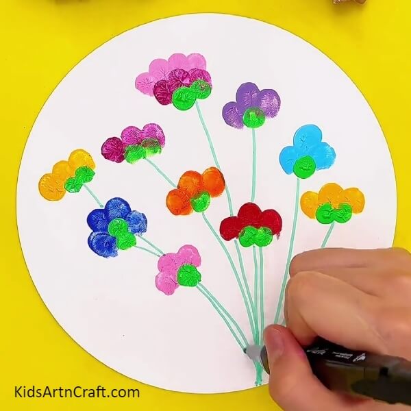 Making stems for each flower with green marker/sketch pen- How to Create Eye-Catching Flower Fingerprint Paintings with Kids 