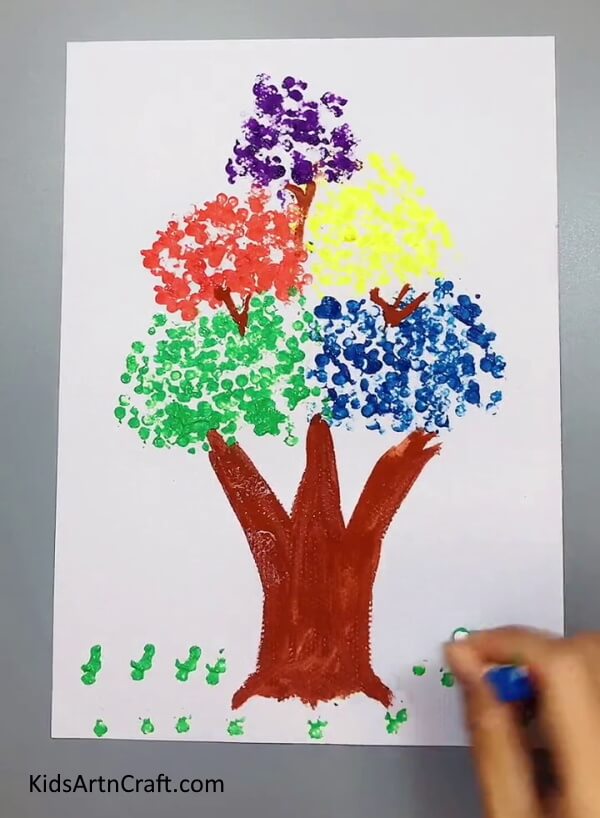 Making Grass - A colorful tree painting made by using earbuds and paint.