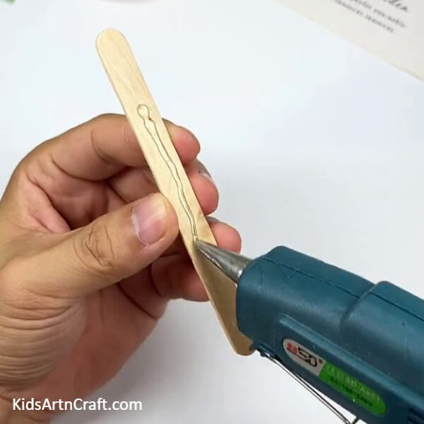 Applying Glue Stick With A Glue Gun-Learn How To Make A Cool Airplane Out Of Popsicle Sticks With This Step-by-step Kid's Tutorial 