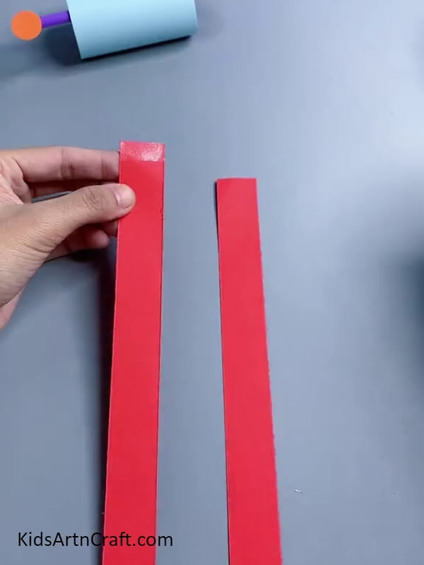 Cutting Two Red Paper Strips- step-by-step guide to make Cool Robot Craft for children