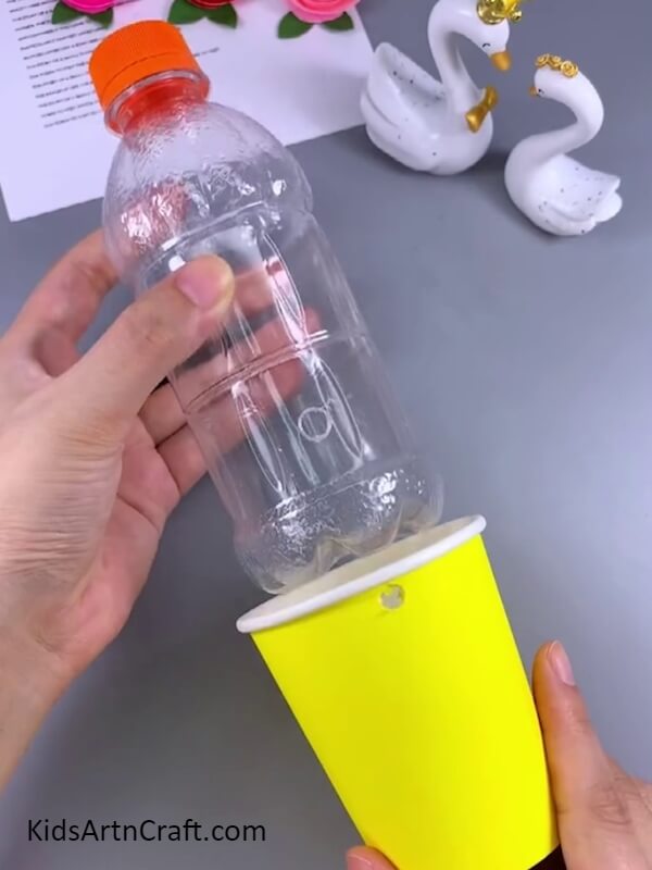 Fitting the two objects together- Let your children use this guide to craft a delightful elephant water dispenser from a plastic bottle.