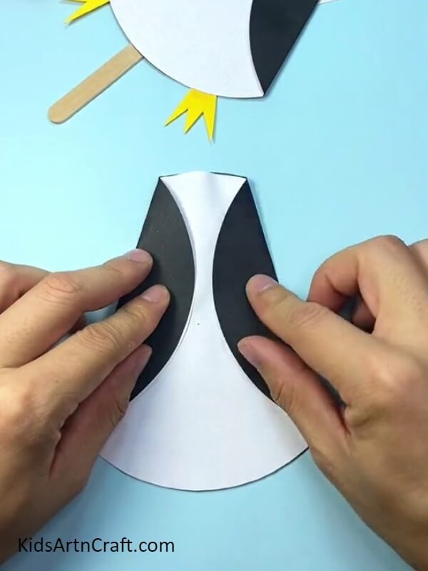 Folding the pasted sheet- Sweet Paper and Popsicle Stick Penguin Creation For Starters