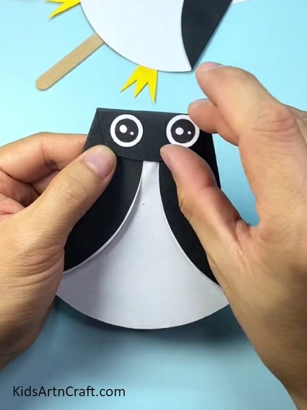 Making two eyes from sheets of paper- Lovely Paper and Popsicle Stick Penguin Craftwork For Rookies