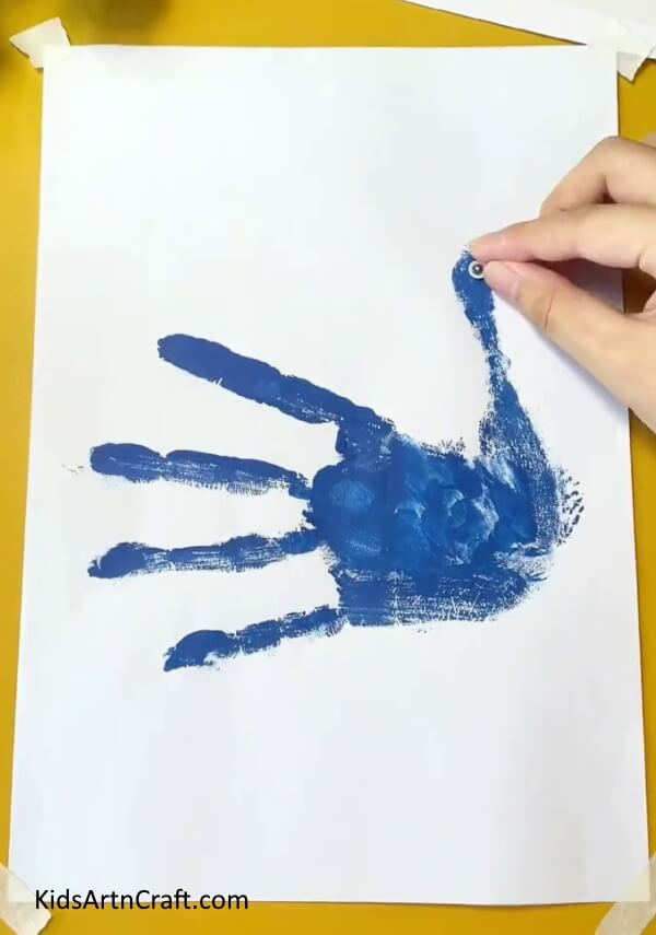 Pasting peacock eyes- A Sweet Peacock Handprint Art & Craft Scheme For Kids