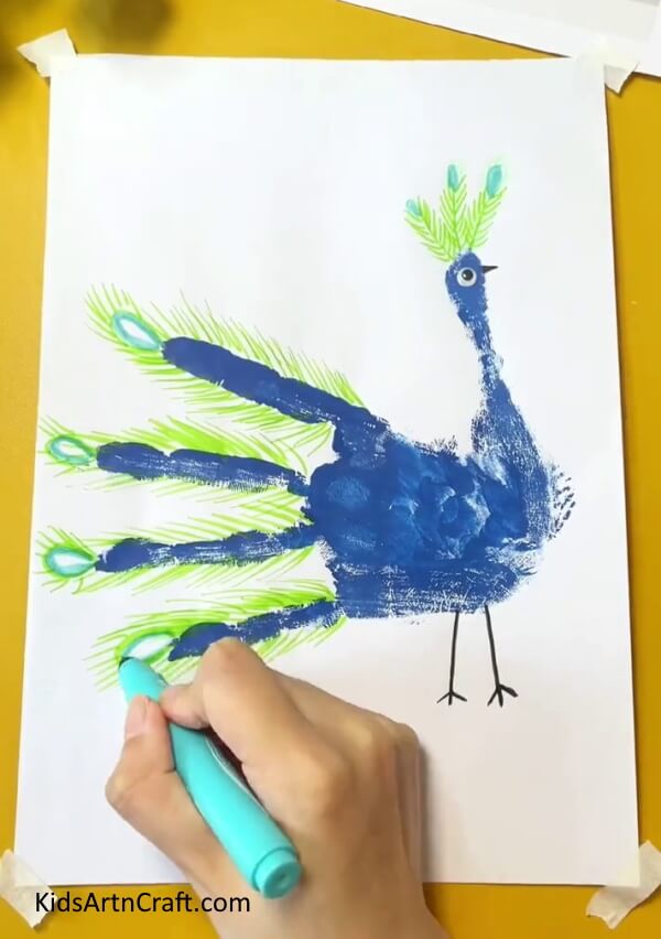 Coloring all the feather patterns- A Delightful Peacock Handprint Art & Craft Idea For Little Ones