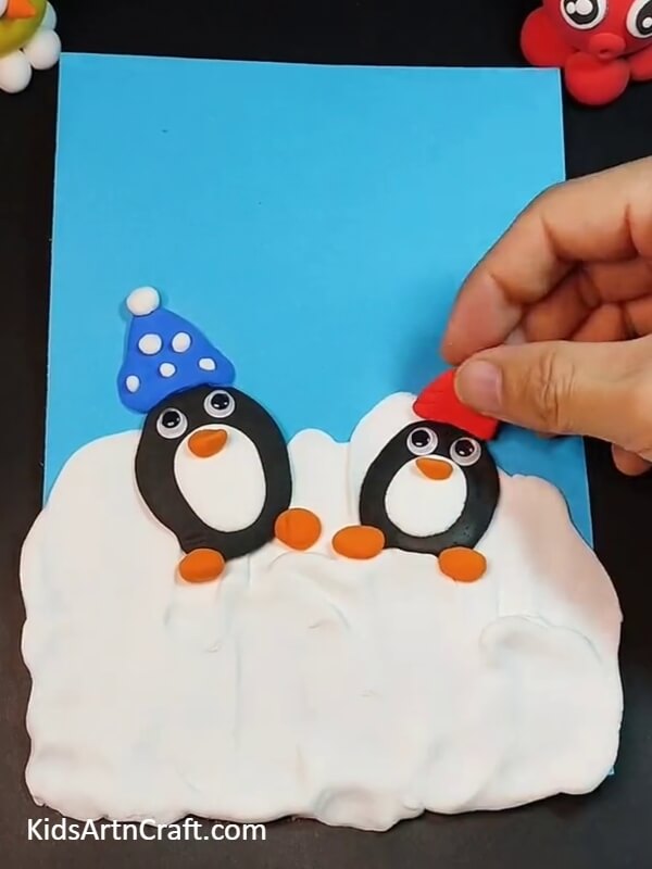 Creating baby penguin and decorating woolen cap- How To Make Kids' Penguin Clay Crafts – A Comprehensive Step-by-step Guide