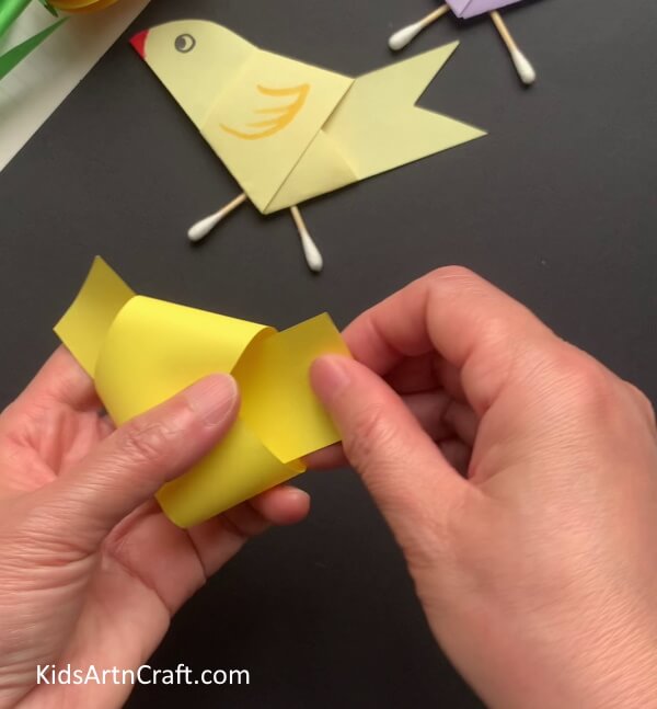 Tying Knot Of Paper Strip - Construct a bird-themed art piece with paper and earbuds.