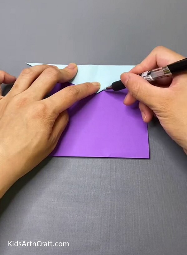Tracing The Outline Of The Triangle On Purple Paper-Create a hand puppet of a bird for kids to play with