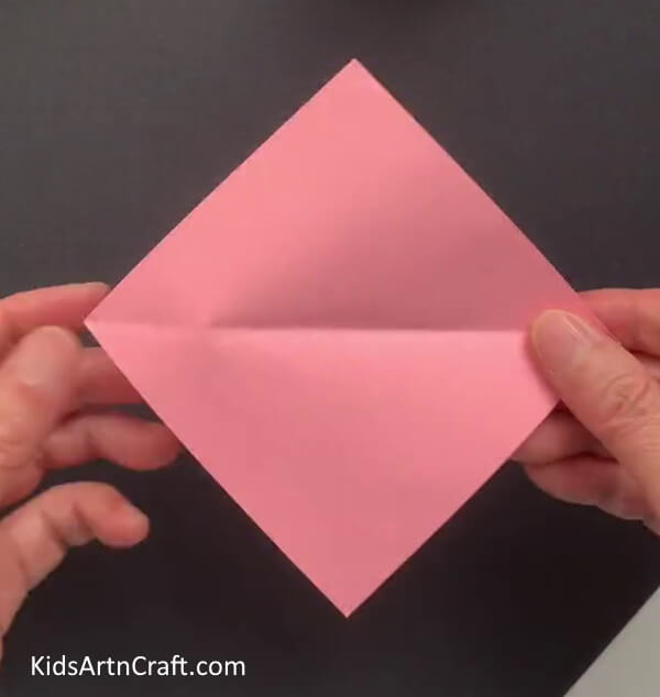 Creasing A Pink Origami Paper Create a Bunny Visage on a Paper Parasol with this Step-by-Step Guide